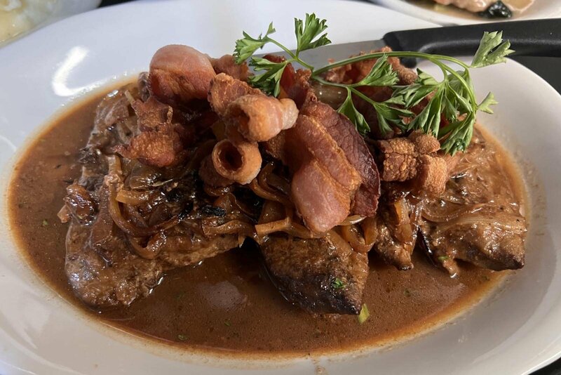 Steak topped with bacon in gravy